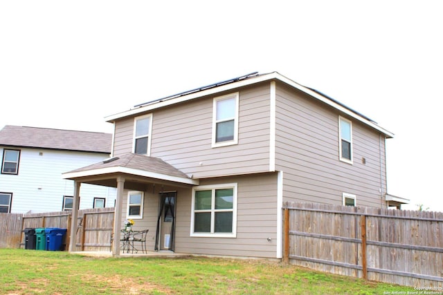 rear view of property with a lawn, a patio area, and a fenced backyard