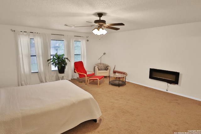 bedroom with carpet floors, baseboards, visible vents, a ceiling fan, and a textured ceiling