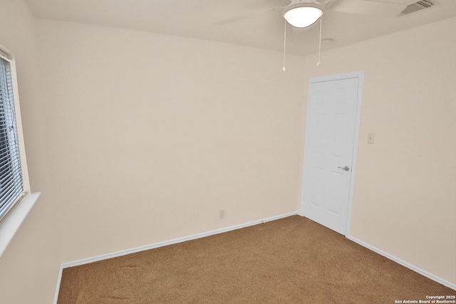 carpeted empty room featuring visible vents, ceiling fan, and baseboards