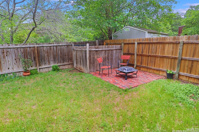 view of yard featuring a fire pit, a fenced backyard, and a patio area