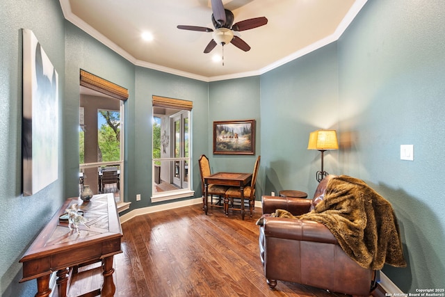sitting room with ornamental molding, ceiling fan, wood finished floors, and a textured wall