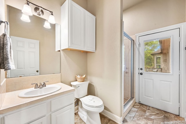 bathroom with baseboards, a stall shower, toilet, and vanity