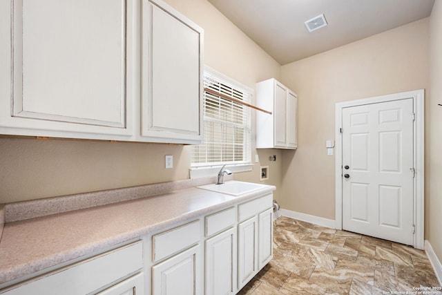 laundry room with a sink, cabinet space, washer hookup, visible vents, and baseboards