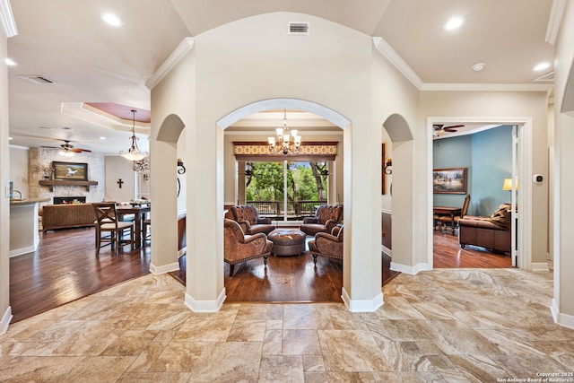corridor featuring crown molding, arched walkways, visible vents, and baseboards