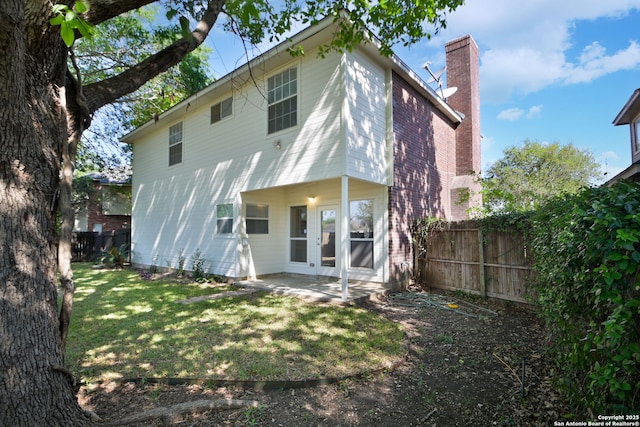 6530 Lochglen, San Antonio, TX 78240 - back of house featuring a chimney, a fenced backyard, a yard, a patio, and french doors