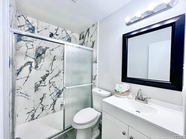bathroom featuring toilet, a textured wall, vanity, a marble finish shower, and a textured ceiling
