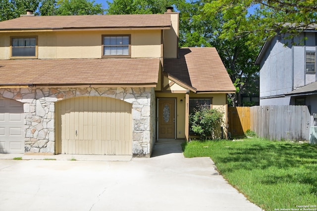 view of front facade with concrete driveway, stone siding, a chimney, a shingled roof, and fence