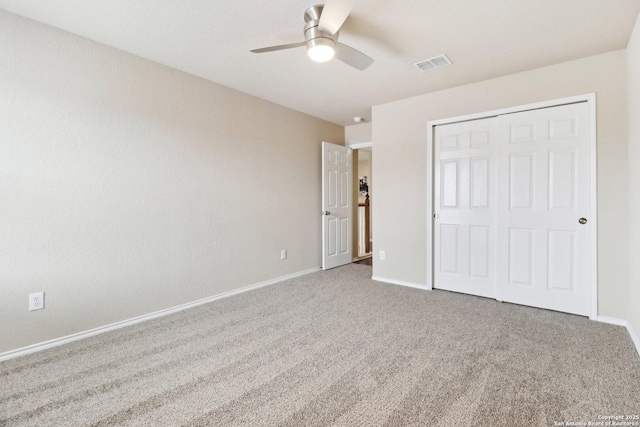 unfurnished bedroom featuring carpet, a closet, ceiling fan, baseboards, and visible vents