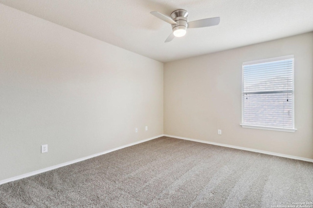 carpeted empty room featuring ceiling fan and baseboards