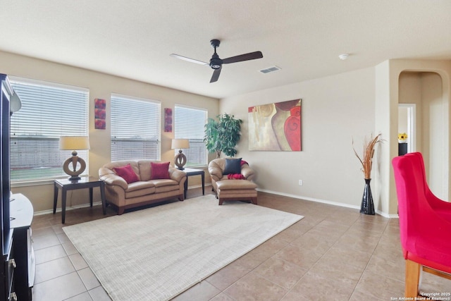 living area with light tile patterned floors, visible vents, ceiling fan, and a healthy amount of sunlight