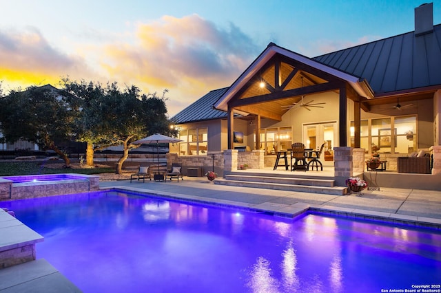 view of swimming pool with exterior kitchen, a patio area, outdoor dining area, ceiling fan, and a pool with connected hot tub