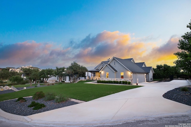 view of front of property featuring driveway, a chimney, a front yard, stucco siding, and a garage