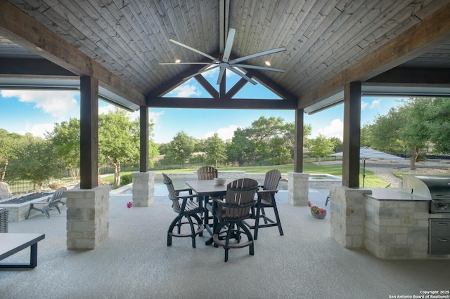 view of patio with ceiling fan, outdoor dining area, grilling area, and exterior kitchen