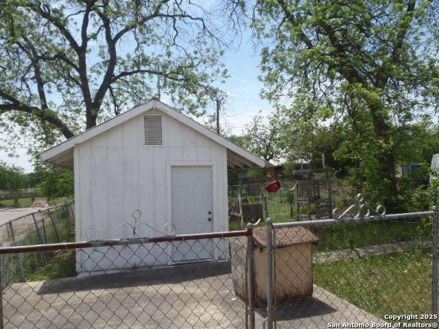 view of outbuilding with fence and an outbuilding