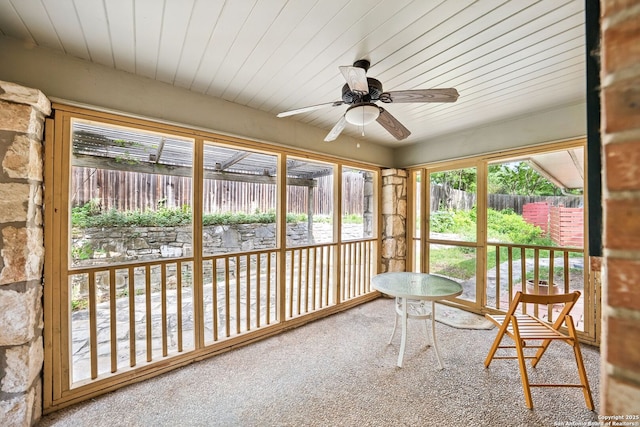 sunroom / solarium featuring wood ceiling, carpet, and a ceiling fan