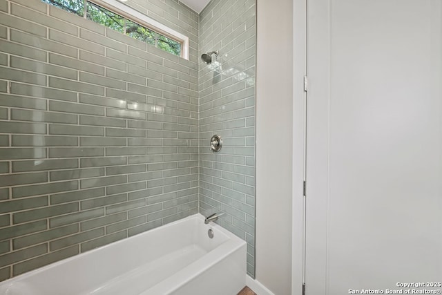full bath featuring bathtub / shower combination and baseboards