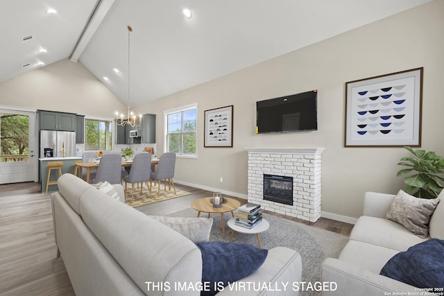 living area featuring beam ceiling, wood finished floors, a chandelier, and baseboards