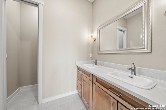 full bathroom with double vanity, a sink, and tile patterned floors