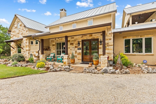 view of front facade featuring a standing seam roof, metal roof, and stone siding