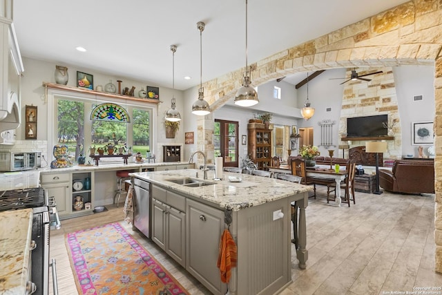 kitchen featuring a sink, ceiling fan, gray cabinets, appliances with stainless steel finishes, and open floor plan