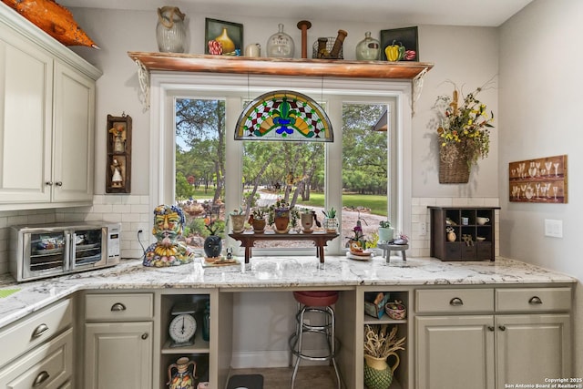 bar with tasteful backsplash, a healthy amount of sunlight, and a toaster