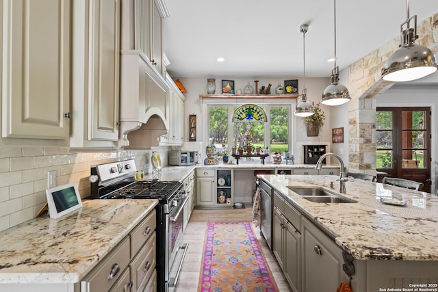 kitchen with a sink, appliances with stainless steel finishes, decorative backsplash, and plenty of natural light