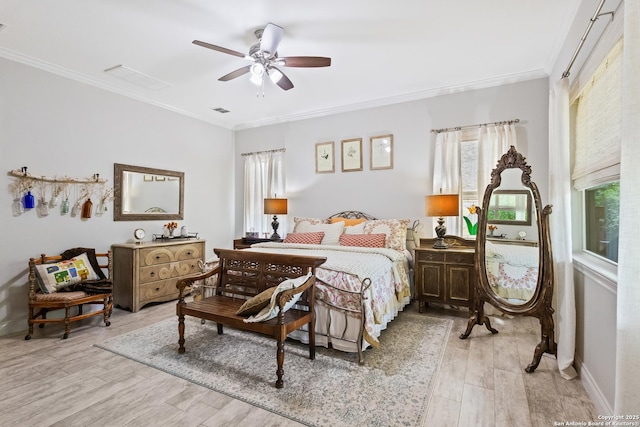 bedroom with visible vents, light wood-style floors, and crown molding