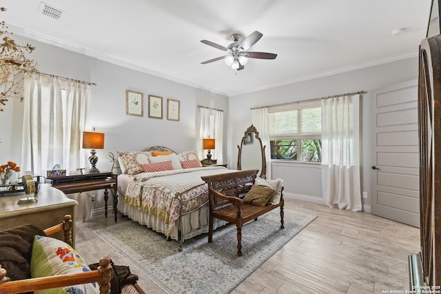 bedroom featuring light wood-style floors, baseboards, visible vents, a ceiling fan, and crown molding
