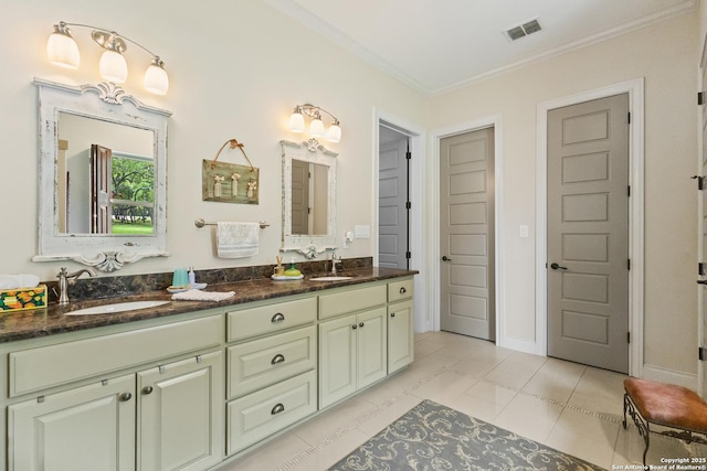 bathroom featuring double vanity, visible vents, ornamental molding, and a sink