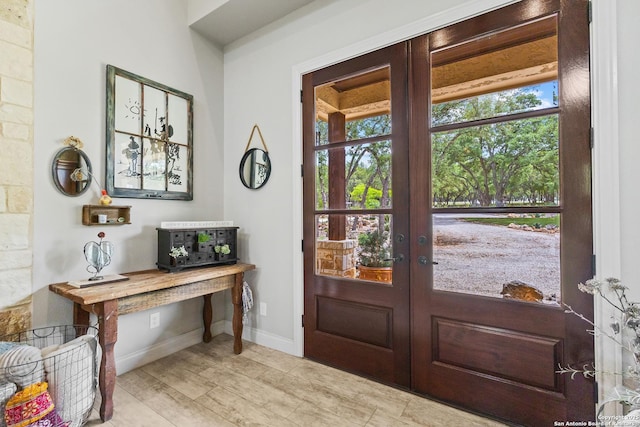 foyer entrance with french doors, plenty of natural light, and baseboards