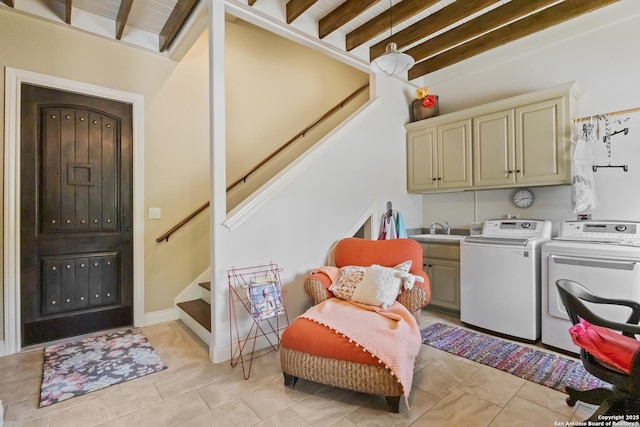 laundry area with light tile patterned floors, a sink, cabinet space, and washer and clothes dryer