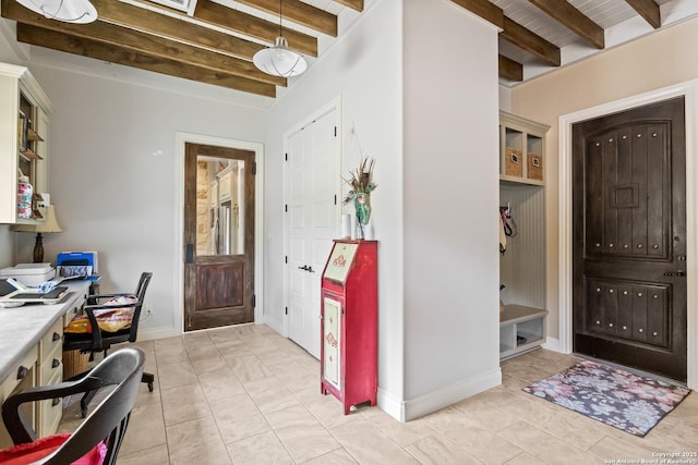 entryway featuring beam ceiling and baseboards