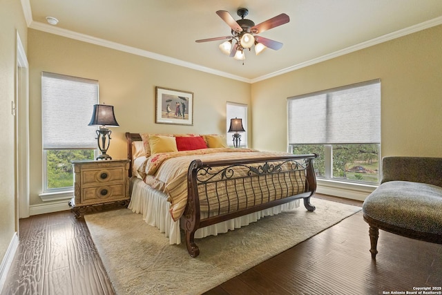 bedroom featuring baseboards, wood finished floors, a ceiling fan, and crown molding