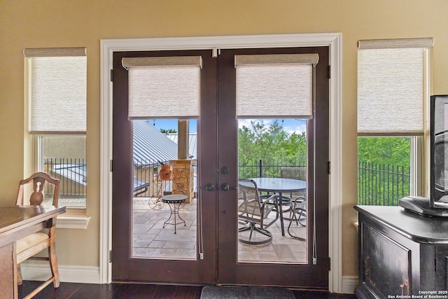 doorway to outside featuring wood finished floors, french doors, and baseboards