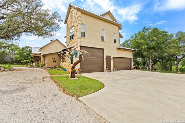 view of side of home with a garage, stucco siding, concrete driveway, and stone siding