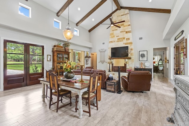 dining space with high vaulted ceiling, beamed ceiling, ceiling fan, and light wood-style flooring