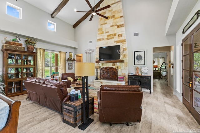 living room featuring visible vents, a fireplace, wood finished floors, a ceiling fan, and high vaulted ceiling