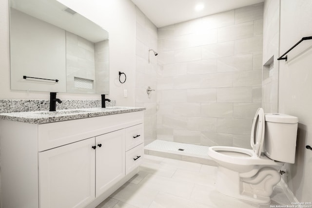 908 Plum, Floresville, TX 78114 - bathroom with toilet, a tile shower, double vanity, and a sink