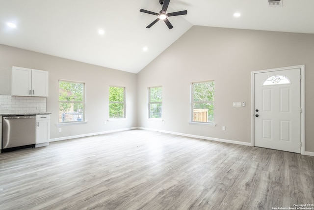 908 Plum, Floresville, TX 78114 - unfurnished living room featuring a wealth of natural light, ceiling fan, high vaulted ceiling, and light wood-style floors