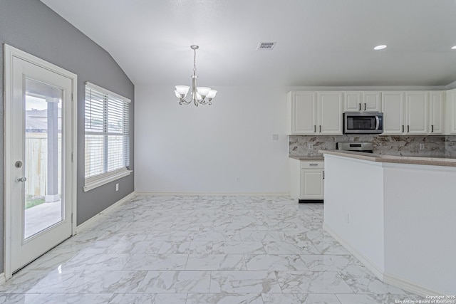 kitchen with stainless steel microwave, white cabinetry, visible vents, an inviting chandelier, and marble finish floor