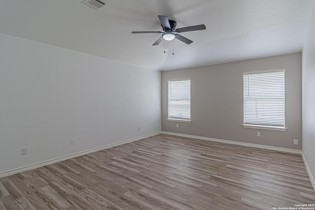 unfurnished room with wood finished floors, visible vents, ceiling fan, and baseboards