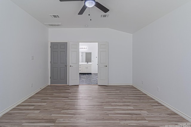 unfurnished bedroom featuring ensuite bath, visible vents, light wood-style flooring, and baseboards
