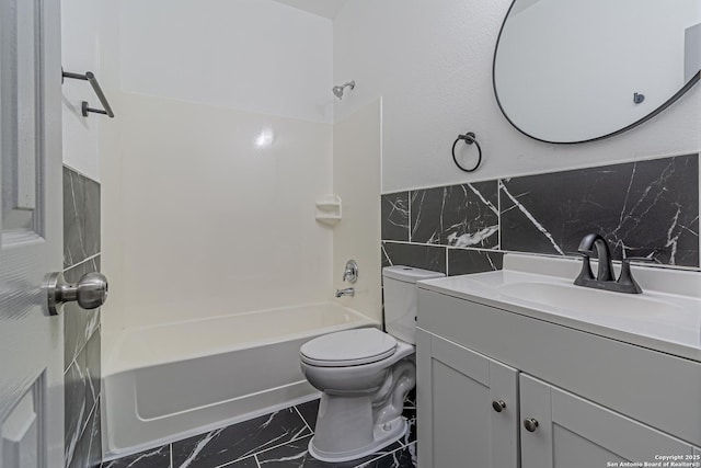 bathroom with marble finish floor, tile walls, toilet, shower / bathtub combination, and vanity