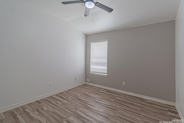unfurnished room with a ceiling fan, vaulted ceiling, wood finished floors, and baseboards