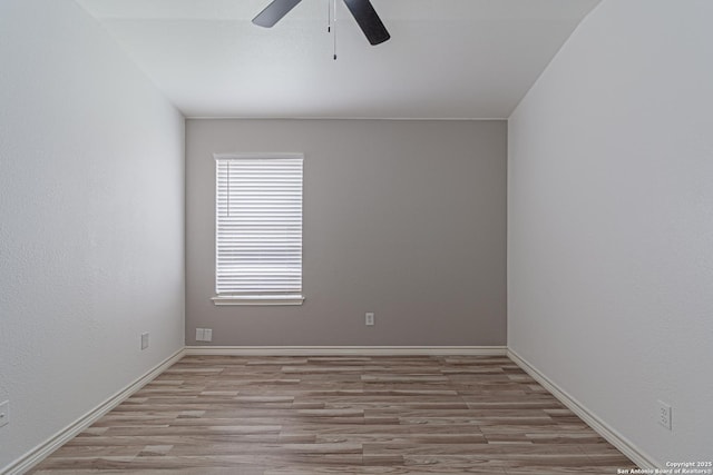 empty room with a ceiling fan, wood finished floors, and baseboards