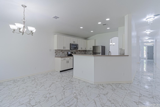 kitchen featuring visible vents, stainless steel appliances, a notable chandelier, and arched walkways
