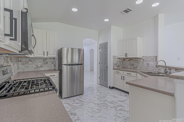 kitchen with a sink, stainless steel appliances, marble finish floor, visible vents, and arched walkways