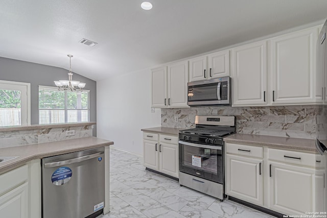 kitchen featuring stainless steel appliances, vaulted ceiling, backsplash, visible vents, and a notable chandelier