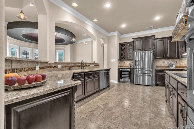 kitchen with decorative backsplash, stainless steel appliances, ornamental molding, a sink, and wine cooler