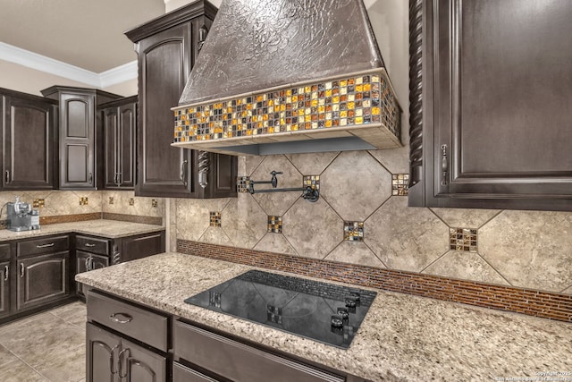 kitchen featuring custom exhaust hood, black electric cooktop, dark brown cabinets, and tasteful backsplash